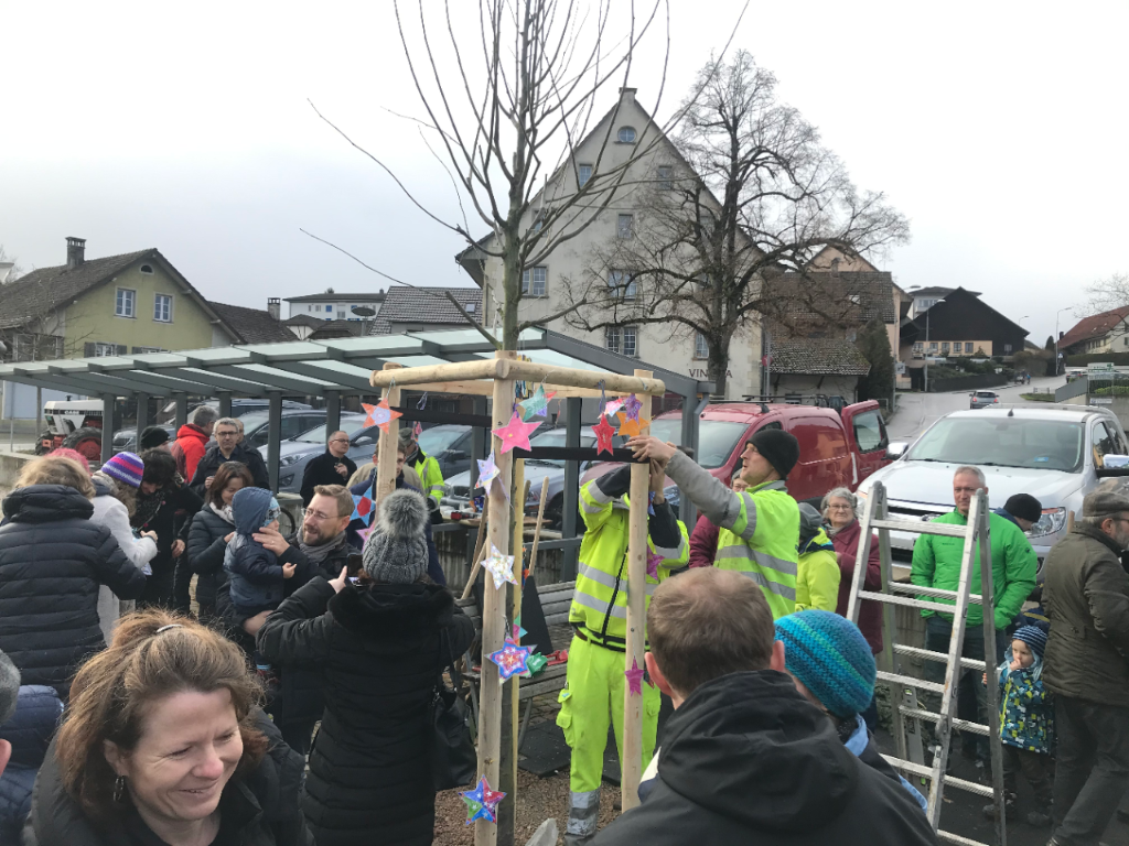 Plusieurs personnes à l'apéritif près de l'arbre nouvellement planté